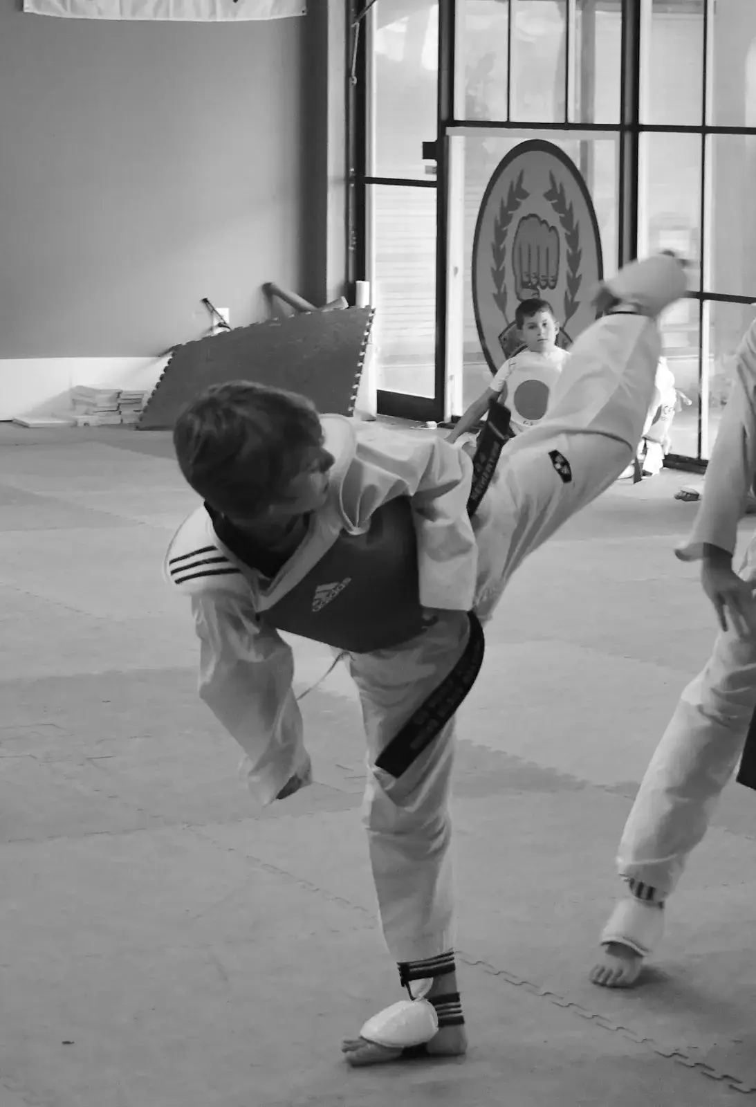 Black and white photo of a student throwing a high kick
